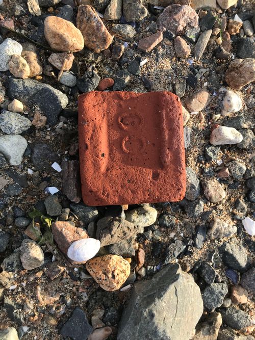 A weathered half-brick stamped with "00"
